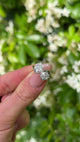 Vintage, 1940s Diamond Cluster Engagement Ring, 18ct White Gold and Platinum held in fingers.