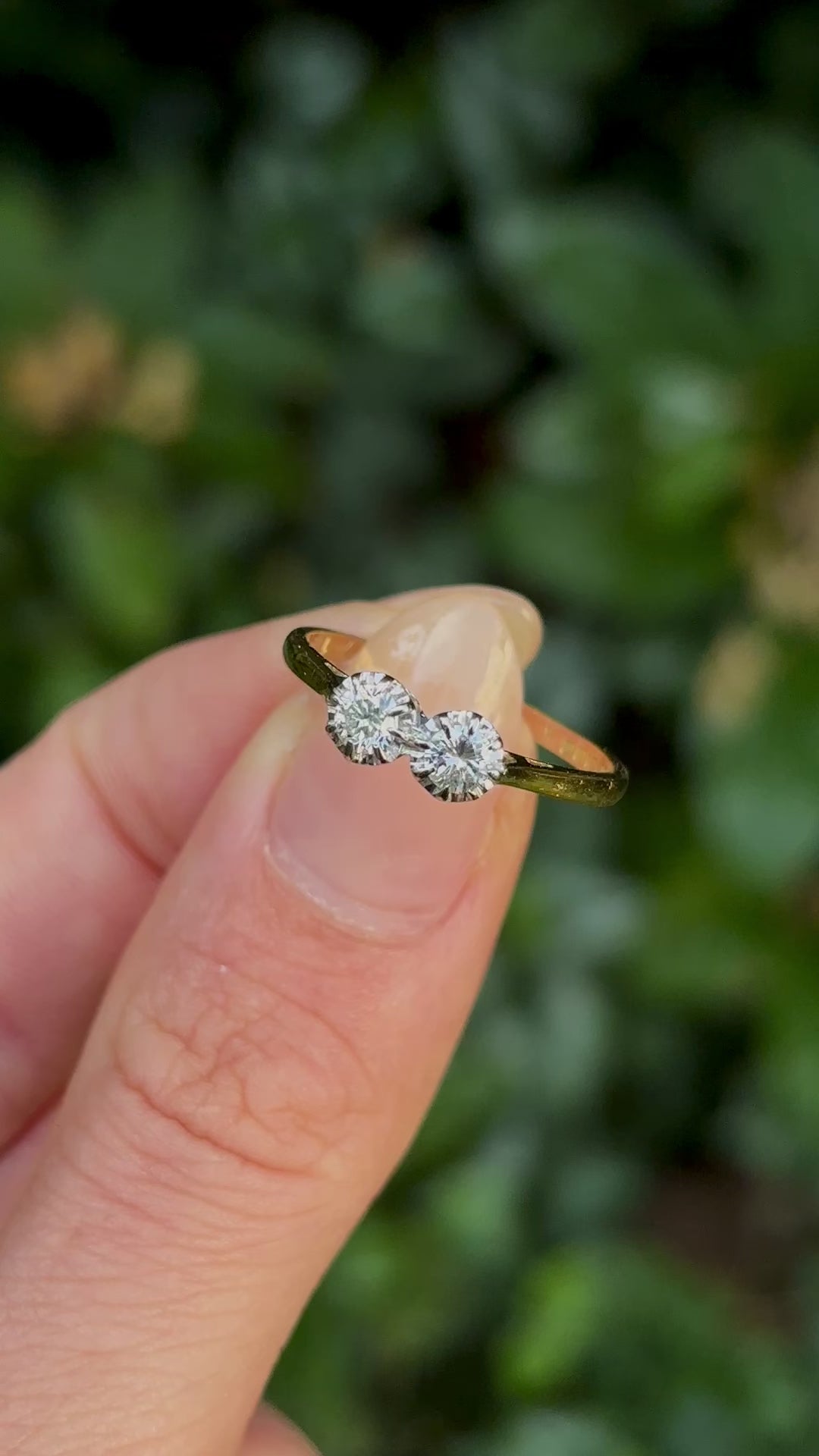 Vintage, 1990s diamond engagement ring held in fingers.