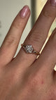 2093-Antique, Edwardian diamond daisy cluster ring held in fingers worn on hand