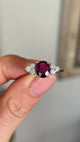 Vintage, 1980s ruby & diamond ring held in fingers.