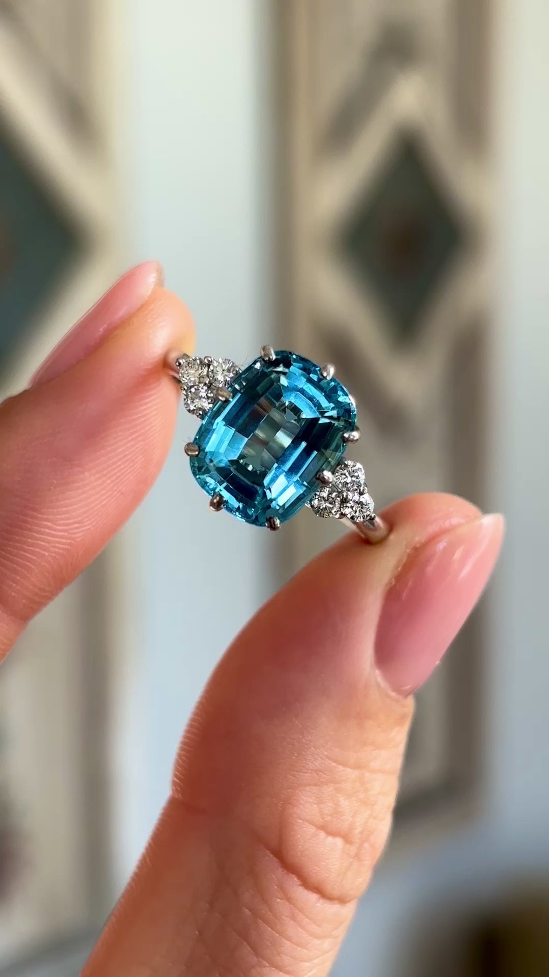 Vintage, 1970s blue topaz & diamond ring held in fingers.