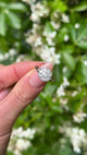 Vintage, Art Deco Diamond Cluster Engagement Ring, Platinum held in fingers.