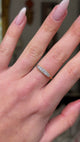 edwardian diamond half hoop ring on hand moving away from lens to give perspective. 