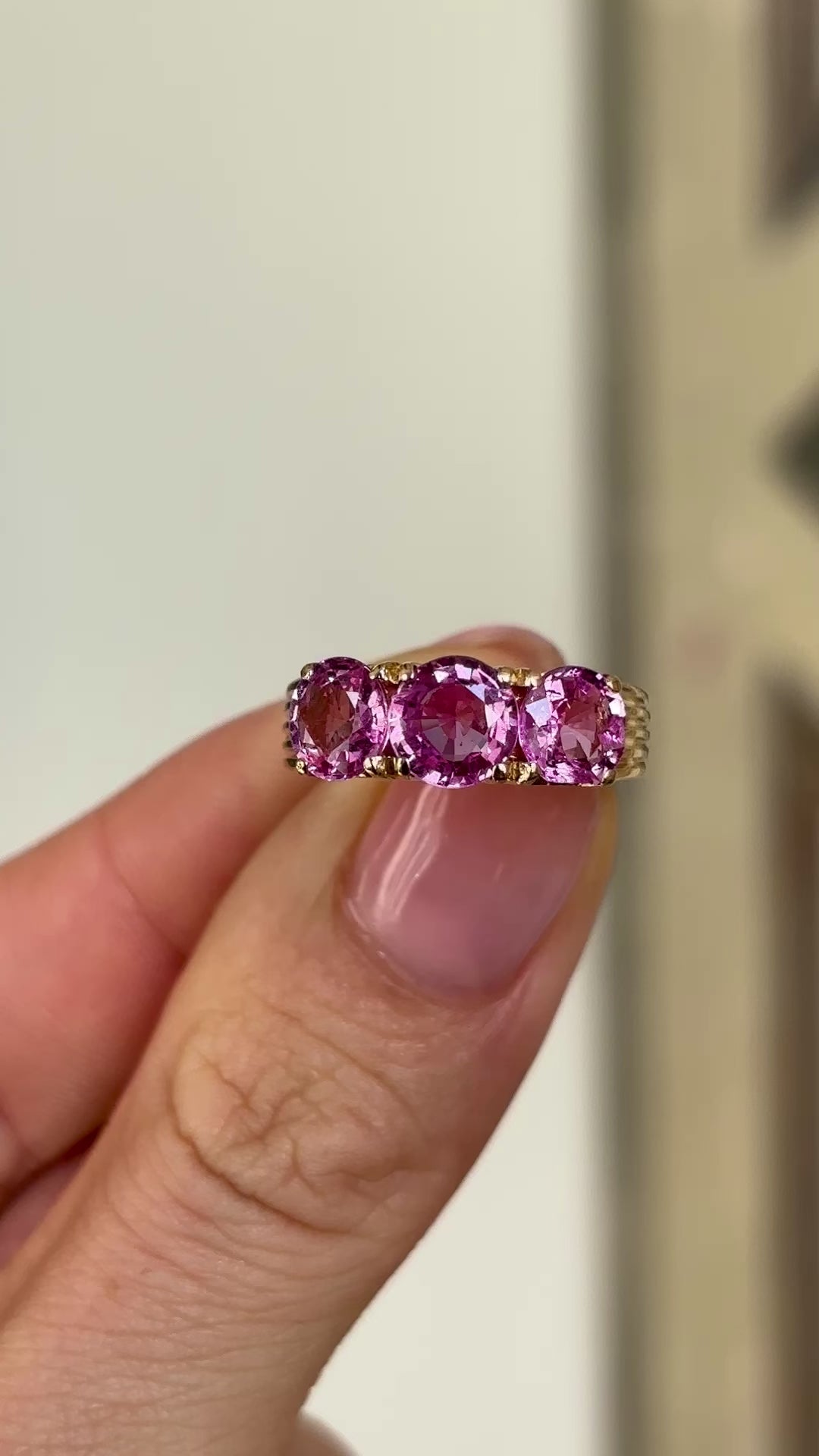 2077-Vintage, 1930s pink sapphire three-stone ring  held in fingers