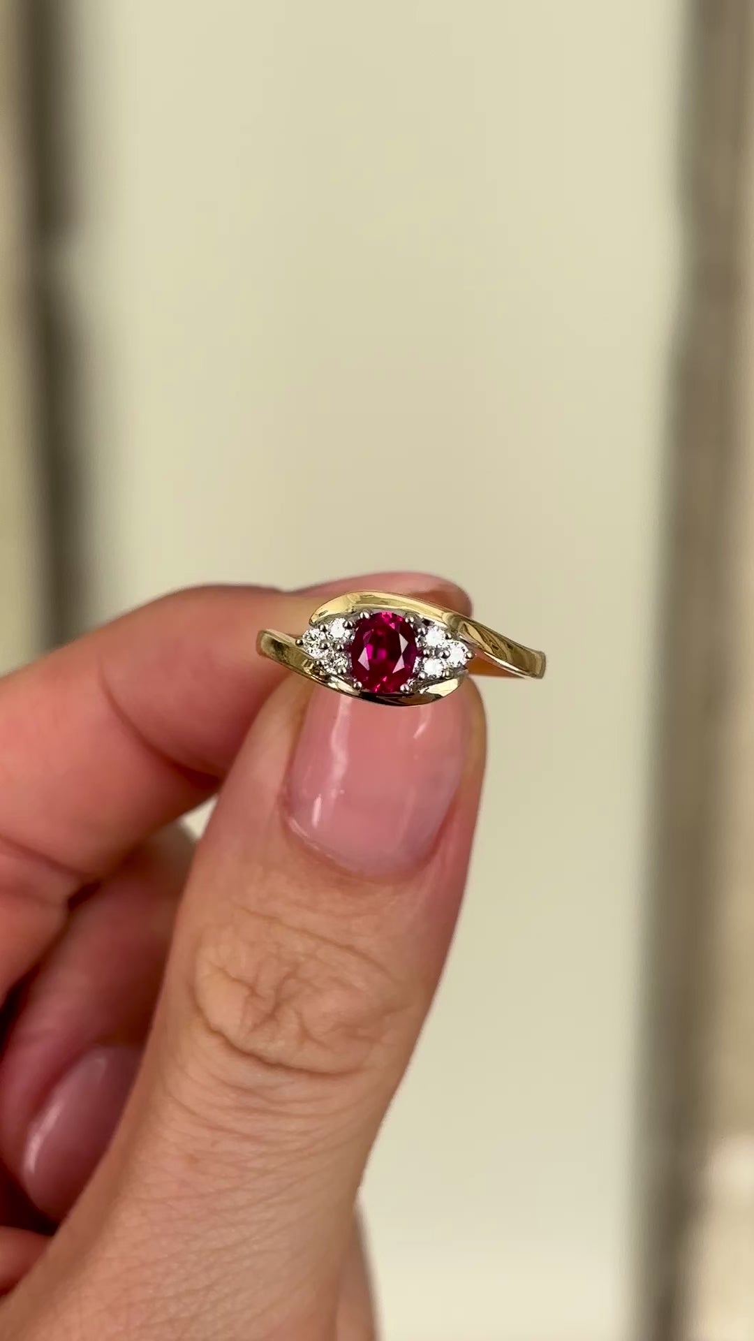 Antique, Edwardian ruby & diamond twist ring held in fingers.