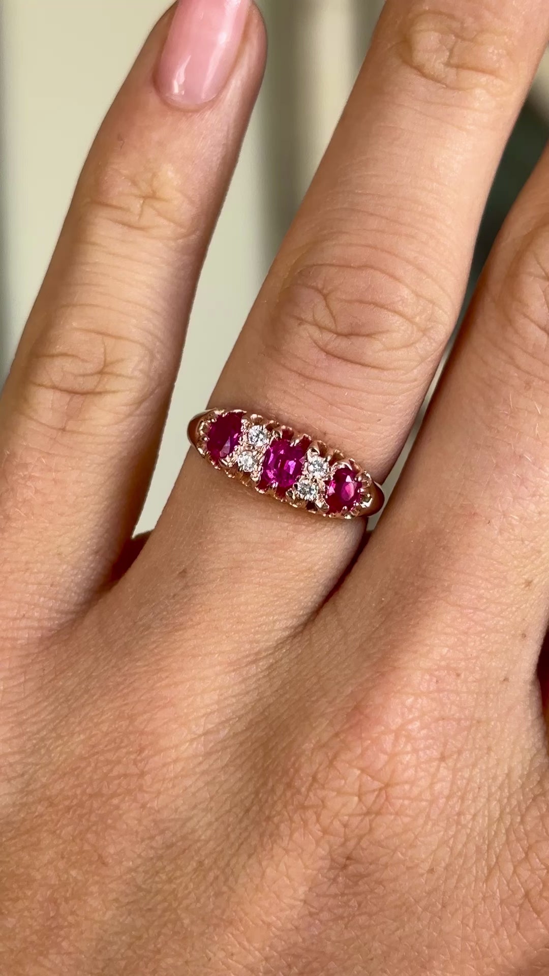 Antique, Victorian pinky-red ruby & diamond half-hoop ring worn on hand.