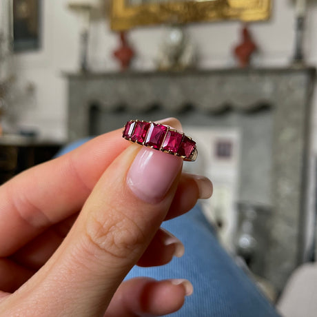 Antique spinel half hoop ring, held in fingers.