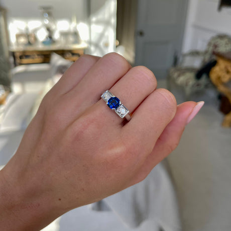 Art Deco three stone sapphire and diamond ring, worn on hand.