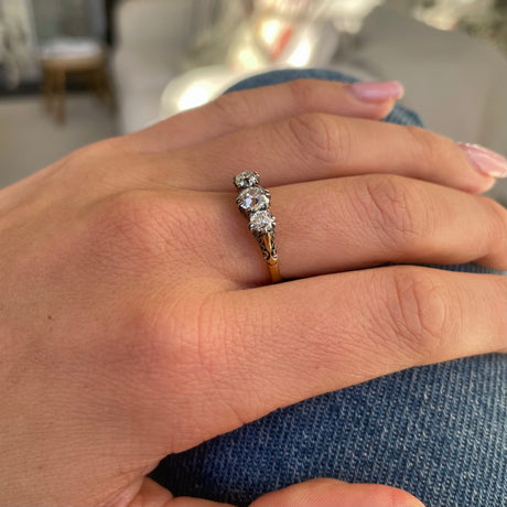 Antique Edwardian three-stone diamond engagement ring, worn on hand.