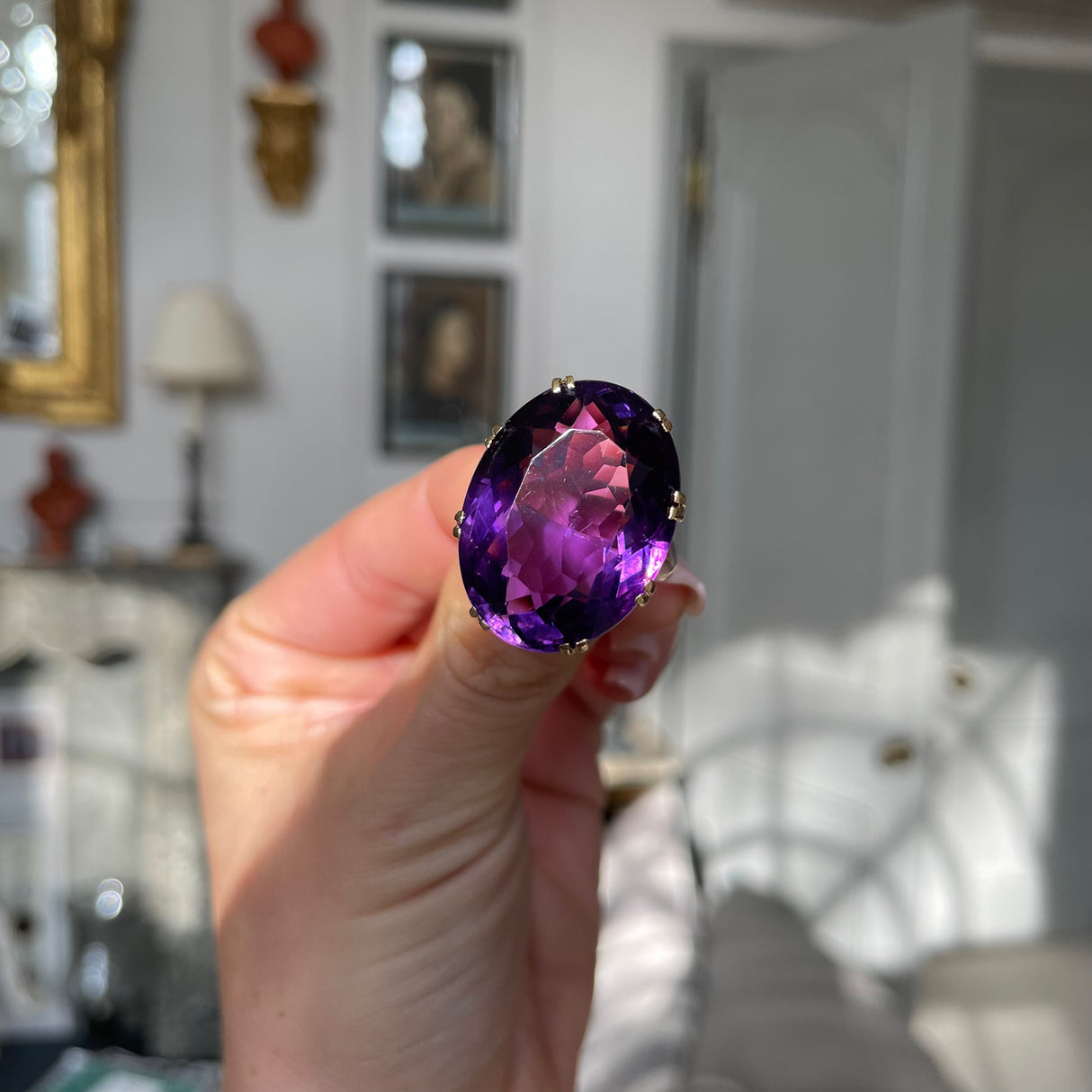 Victorian amethyst cocktail ring, held in fingers.
