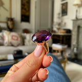 Victorian amethyst cocktail ring,  held in fingers.