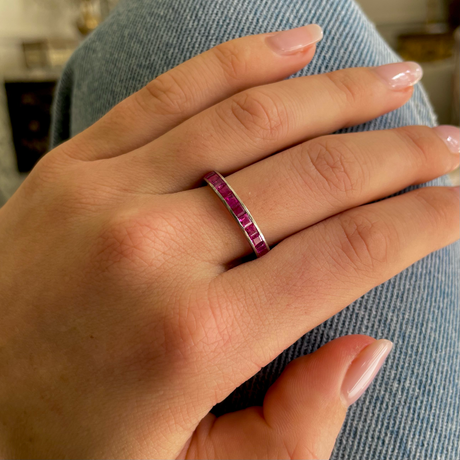 Pink sapphire eternity ring, worn on hand.