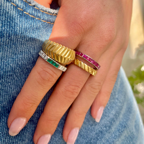 Pink sapphire eternity ring, worn on hand in a stack.