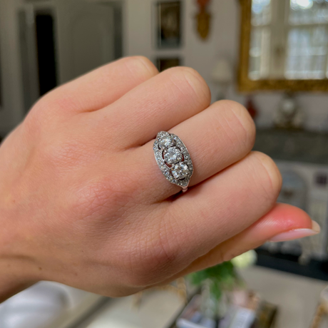 Art Deco three-stone diamond engagement ring, worn on hand.