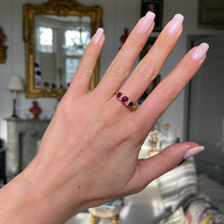 Victorian three-stone ruby and diamond engagement ring, worn on hand. 