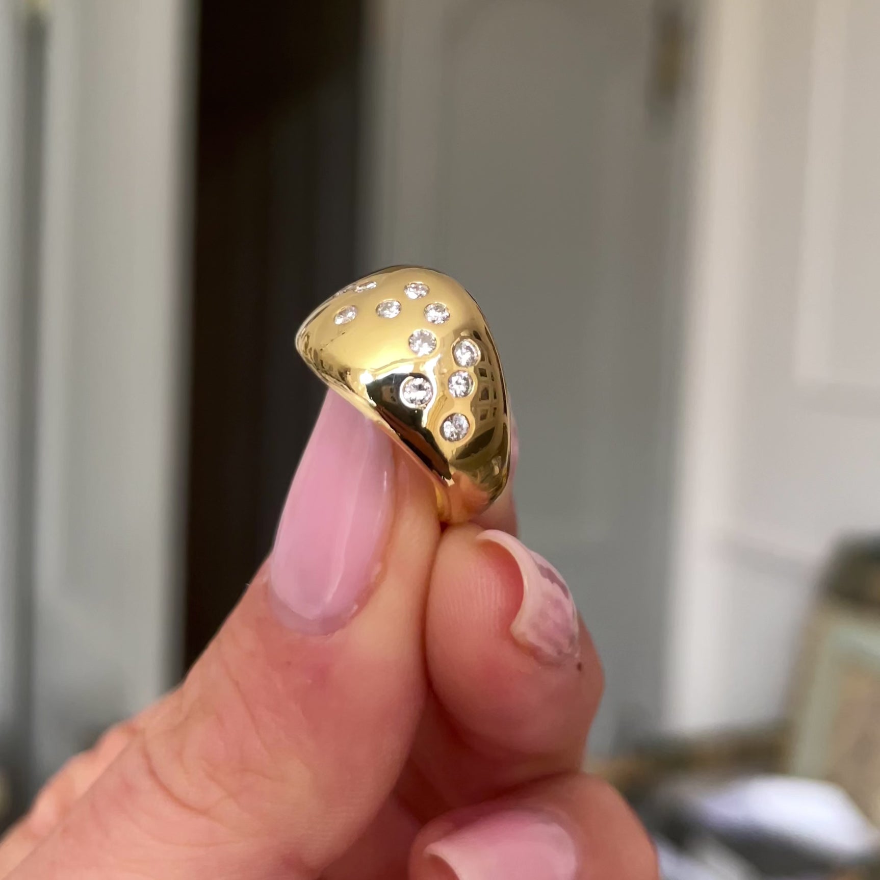 Vintage French diamond constellation ring, held in fingers and rotated to give perspective.